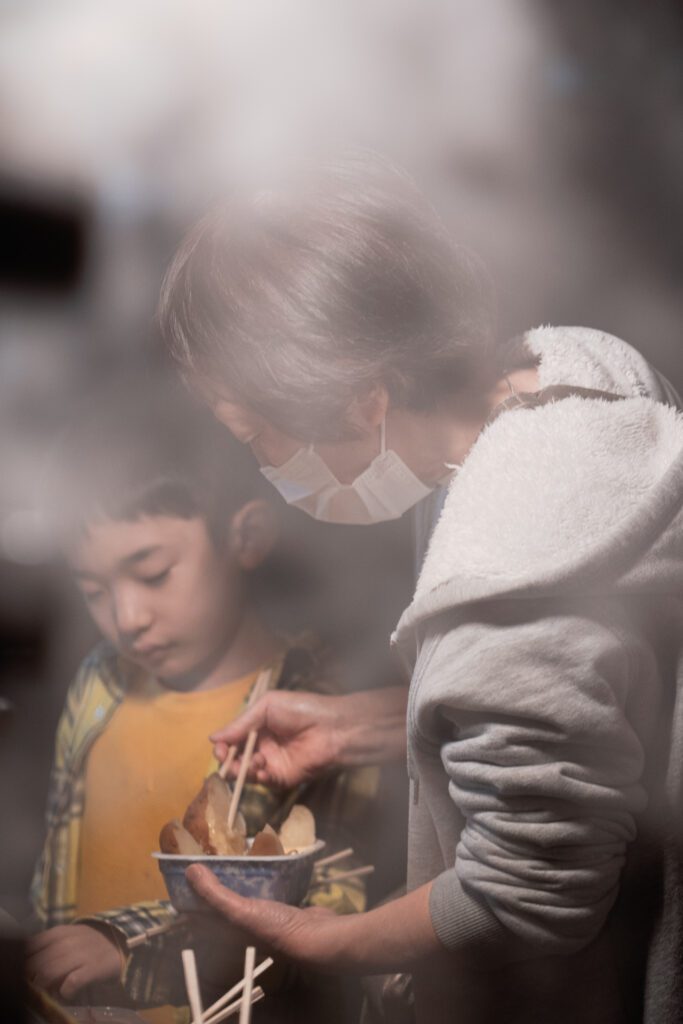 A woman and a child eating potatoes