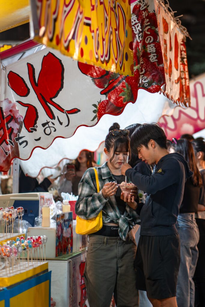 Deux personnes mangeant un plat during un festival japonais