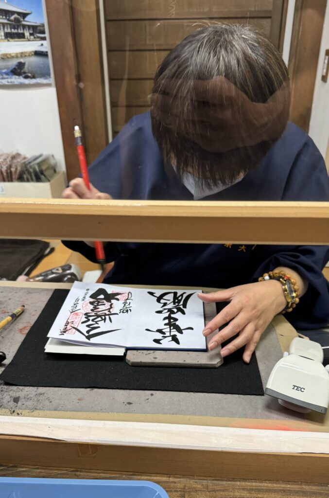 Personne dessinant un goshuin au pinceau