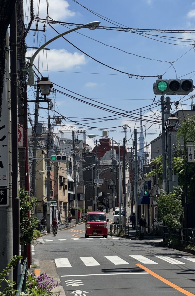 A red car in a street in Yanaka